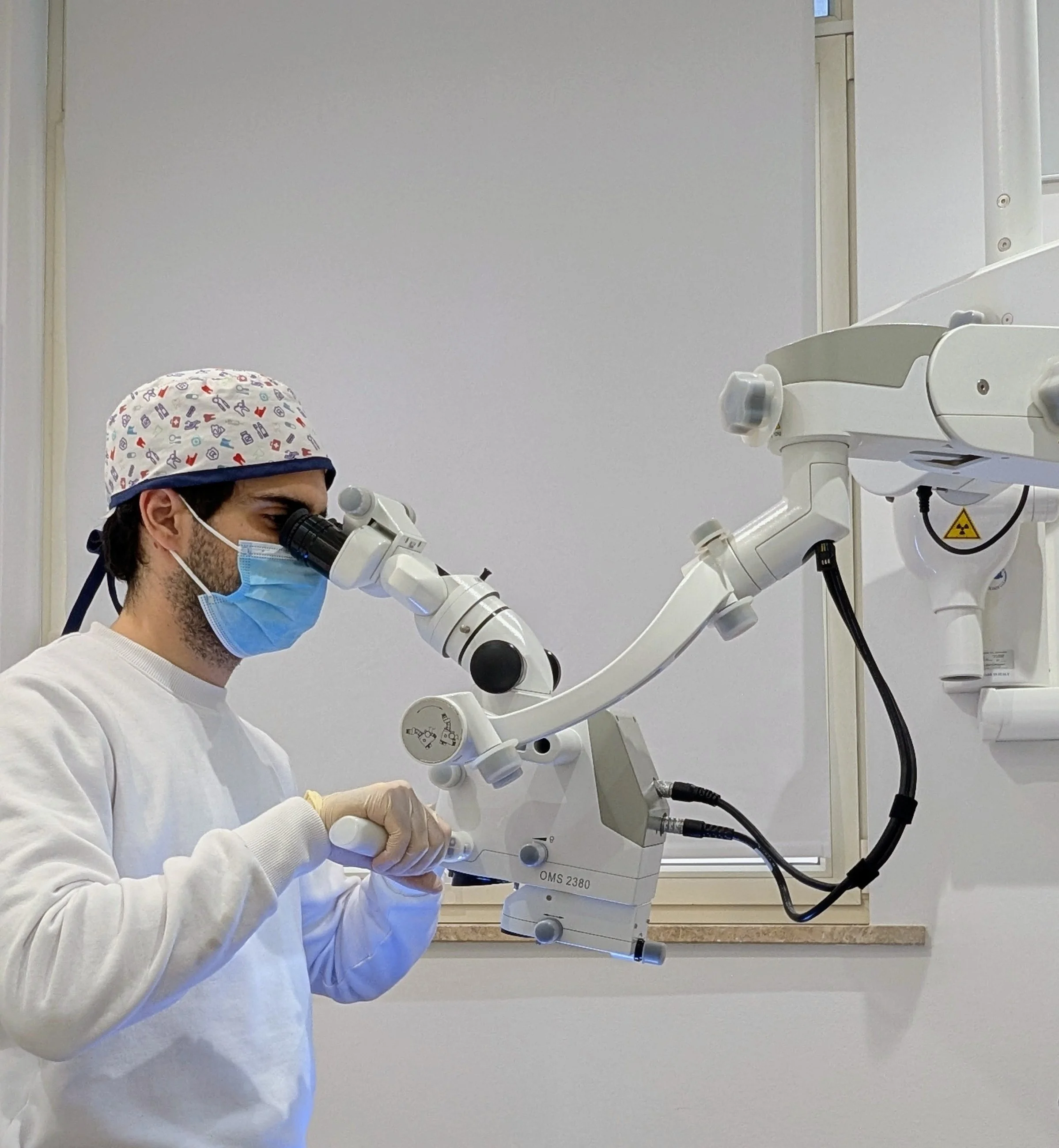 Dott. Trentadue mentre esegue un’intervento con l’ausilio del microscopio operatorio, strumento imprescindibile per garantire il massimo del successo e della microinvasività in tutte le discipline odontoiatriche. Studio Medico Moro Parma